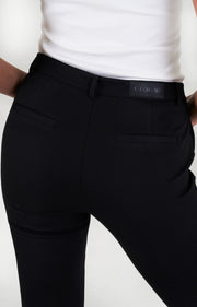 Lange vrouw draagt zwarte bootcut broek met lange lengtematen, vegan leather label