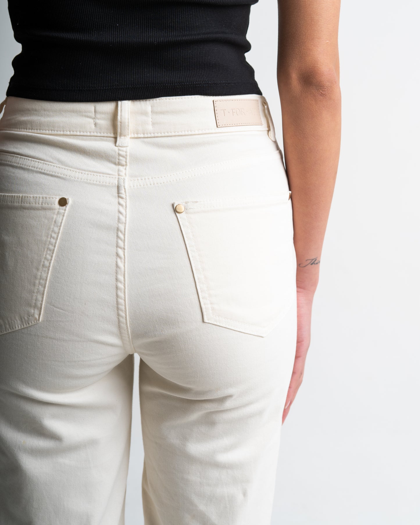 Achterkant detail off white stretch jeans golden button