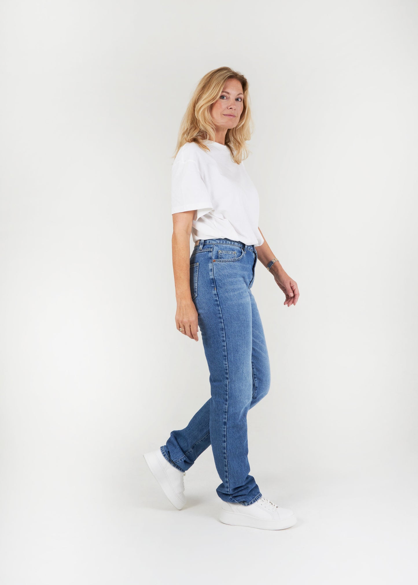 Vrouw met lange benen draagt regular washing straight leg spijkerbroek