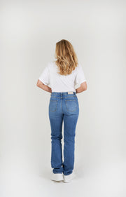 Vrouw met lange benen draagt regular washing straight leg spijkerbroek
