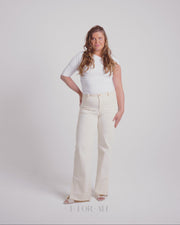 Woman with off white stretch jeans golden button